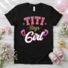 Black t-shirt with "TITI Says Girl" text, pink glitter accents, and baby footprints graphic