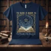 Navy t-shirt with "To Ban A Book Is To Fear Its Magic" quote and a celestial moon and star graphic
