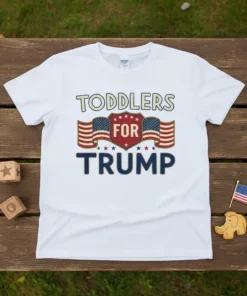 Toddlers For Trump t-shirt featuring bold text, American flags, and a shield graphic in patriotic colors