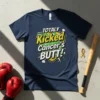 Navy t-shirt with bold yellow and green text that reads "TOTALLY Kicked Cancer's BUTT!" in a comic book style, featuring