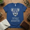 Blue t-shirt with white text reading "TOTALLY KOALIFIED" and a sketch-style koala wearing a tuxedo and bow tie
