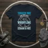 Touch Me And Your First Wrestling Lesson Is Free text on a navy t-shirt with a wrestler graphic in the
