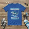 Tralalero Tralala text with a cartoon shark wearing running shoes on a blue t-shirt