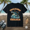 Tralalero Tralala text above a cartoon shark surfing a wave, wearing sneakers, on a black t-shirt