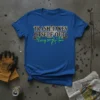 Blue t-shirt with bold white and black text reading "TRASH TAKES ITSELF OUT" and green script text "Every single time"