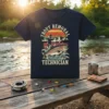 Trout Removal Technician T-Shirt featuring a fisherman reeling in a trout against a sunset mountain backdrop