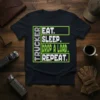 TRUCKER EAT. SLEEP. DROP A LOAD. REPEAT. text design in white and green on a black t-shirt for truck drivers