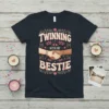 Twinning With My Bestie text with two hands shaking design on a navy t-shirt, featuring floral and heart accents