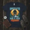 Undefeated Hide & Seek Champion Bigfoot t-shirt design with a silhouette of Bigfoot on a mountain peak against a large