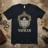 Black t-shirt with gold ornate crest framing St. Peter's Basilica and the word VATICAN below, representing Vatican City travel