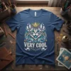 Graphic t-shirt featuring a stylized, crowned cat with blue and gold accents and the text "VERY COOL" below