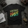 Black t-shirt with "VINTAGE 1965" text in colorful retro font, set against a subtle circuit board pattern