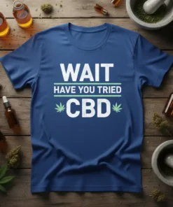 Blue t-shirt with white text "WAIT HAVE YOU TRIED CBD" and green accents, surrounded by CBD oil bottles and hemp