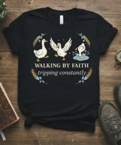 Black t-shirt with "Walking By Faith Tripping Constantly" quote and three cartoon ducks, one falling