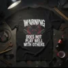Black t-shirt with white text "WARNING DOES NOT PLAY WELL WITH OTHERS" and a red-eyed devil graphic