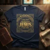 Navy blue t-shirt with gold ornate design featuring text "WARNING! I may start talking about JESUS at any time"