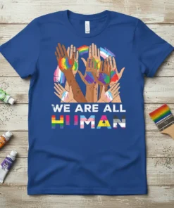 We Are All Human t-shirt design with diverse hands painted in pride flags and text "WE ARE ALL HUMAN"