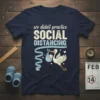 T-shirt with text "we didn't practice SOCIAL DISTANCING" featuring a stork carrying a baby and a measuring tape