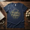 Gold "Wedding Officiant" text with wedding rings graphic on a navy blue t-shirt