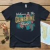 Welcome To The Gunshine State t-shirt design with tropical flowers and gears
