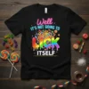 Black t-shirt with "Well It's Not Going To LICK ITSELF" text and rainbow lollipop graphic, surrounded by candies