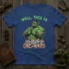 Well, This Is Orc-Ward T-Shirt featuring a muscular green orc character with a punny phrase, ideal for fantasy and gaming