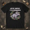 WE'RE HOPING IT'S A DINOSAUR text above a triceratops surrounded by floral wreath graphic on a black t-shirt
