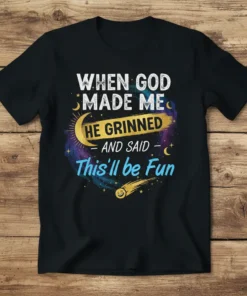 When God Made Me He Grinned And Said This'll be Fun quote on a black t-shirt with celestial graphics