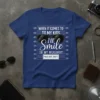 Blue t-shirt with "When It Comes To My Kids I'll Smile In My Mugshot" text and sunglasses graphic, resembling a