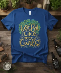 Blue t-shirt with "Wild Like my Curls" in glittery gold and green calligraphy, surrounded by decorative swirls and stars
