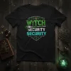 Black t-shirt with green and teal text "Witch Security Security" and a broom graphic, surrounded by mystical symbols