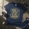 Navy blue t-shirt with gold glitter text "Woke Up Sexy As Hell Again" in ornate font