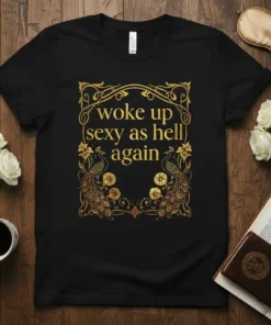 Black t-shirt with gold text "woke up sexy as hell again" and ornate peacock graphics