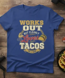 T-shirt with "WORKS OUT BUT CLEARLY LOVES TACOS FUEL & GAINS" text, featuring tacos and a muscular arm graphic