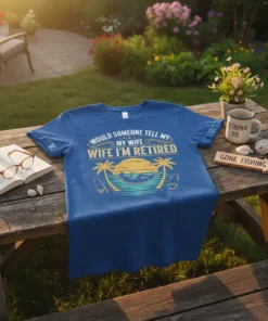 Blue t-shirt with yellow text "Would Someone Tell My Wife I'm Retired" and a hammock graphic with palm trees
