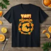 YAY! Vitamin text design with a circular frame of oranges and leaves on a black t-shirt