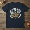 Yep I Talk To Chickens quote on a navy t-shirt, featuring distressed white and gold lettering surrounded by feathers and