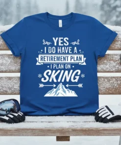 Yes I Do Have A Retirement Plan I Plan On Skiing text design on a blue t-shirt with mountain graphic
