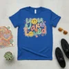 Retro "You Are Loved" t-shirt with colorful smiley faces, flowers, and stars in a groovy font