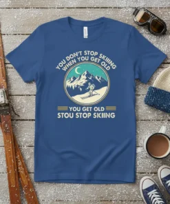 Vintage skiing quote t-shirt: "You Don't Stop Skiing When You Get Old." Features a mountain scene with a skier