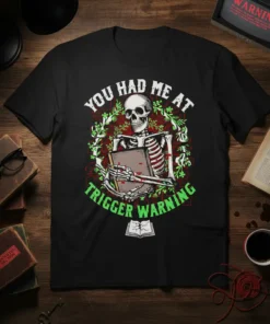Skeleton holding a book with "You Had Me At Trigger Warning" text, on a black t-shirt, gothic design