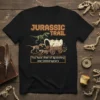 T-shirt with "Jurassic Trail" and "You have died of dysentery and Velociraptors" text, featuring cartoon dinosaurs and a covered wagon