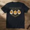 T-shirt with the text "You know why I'm here." above a crest featuring three deviled eggs, two decorated like flowers