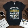Black t-shirt with white, yellow, and blue text reading "YOU PEOPLE must be EXHAUSTED FROM watching ME DO everything" with