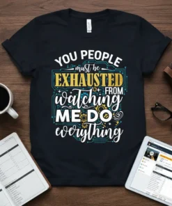 Black t-shirt with white, yellow, and blue text reading "YOU PEOPLE must be EXHAUSTED FROM watching ME DO everything" with