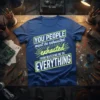 Blue t-shirt with neon yellow text: "YOU PEOPLE must be exhausted exhausted FROM WATCHING ME DO EVERYTHING" and sunburst graphic