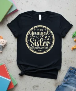Text "I'm The Youngest Sister Rules Don't Apply To Me" in a circle on a black t-shirt, with decorative stars
