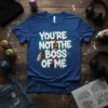 Blue t-shirt with white graffiti-style text "YOU'RE NOT THE BOSS OF ME" and a red devil holding a spray can