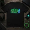 Black t-shirt with neon green "YUP!" text and blue lightning bolt, surrounded by circuit board graphics