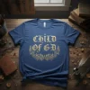 Child of G·D text with ornate floral wreath and cross on blue t-shirt, faith-inspired design